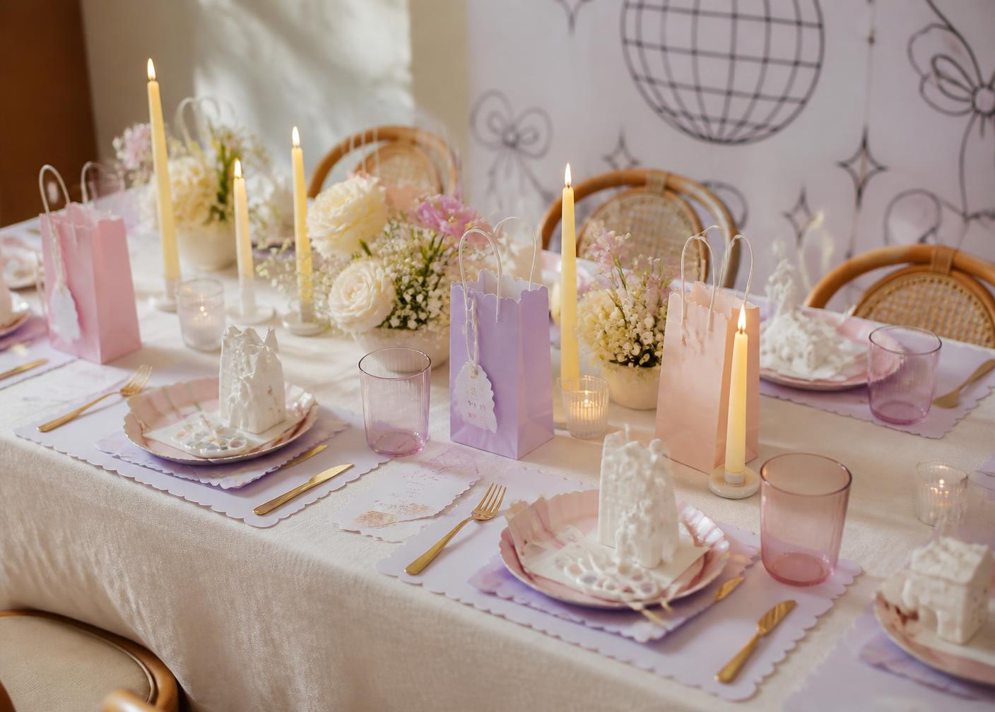 Children's birthday party table set with paint kits, blush and lilac paper goods